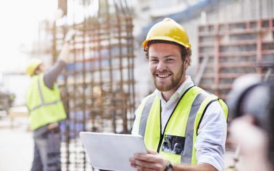 portrait-confident-construction-worker-with-digital-tablet-at-construction-site-CAIF11590